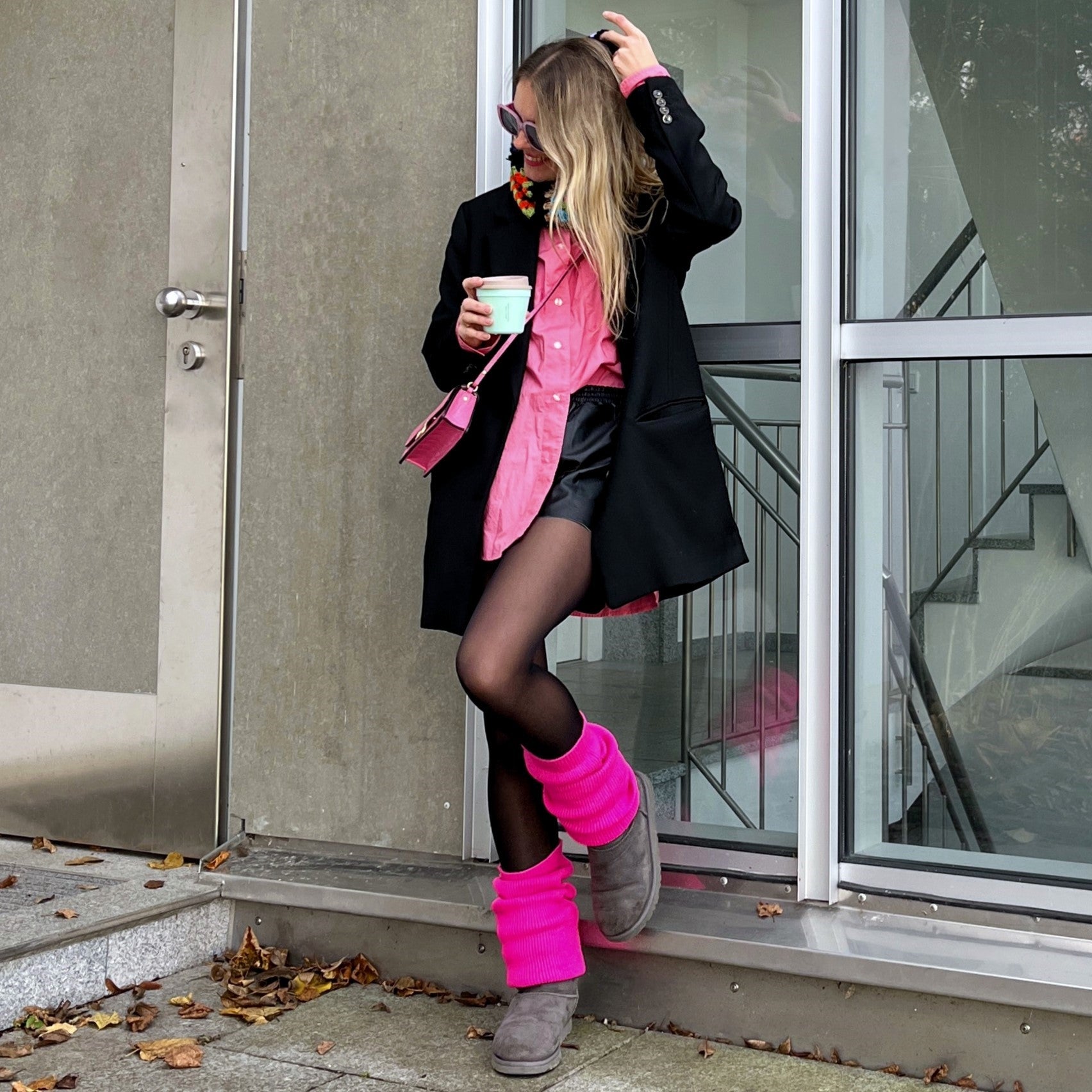 hot pink leg-warmers, worn over leather-like black leggings, and